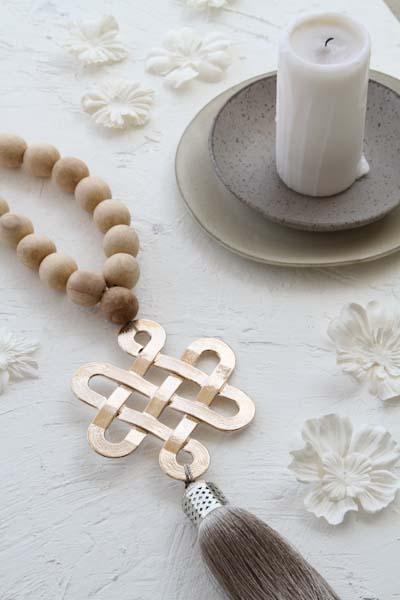 תכשיט קיר ייחודי עשוי חרוזי עץ טבעיים עם סמל קשר אהבת אין סוף מצופה זהב אדום וגדיל משי אלגנטי. עיצוב רוחני ומעוצב לבית, המשלב סמלים של אהבה, הרמוניה ומזל טוב. קישוט קיר מודרני בעבודת יד להוספת סטייל ואווירה חיובית לבית.  
תכשיט קיר, קישוט קיר רוחני, קשר אהבת אין סוף, עיצוב לבית, חרוזי עץ טבעיים, קישוט לבית עם משמעות, תכשיט קיר מעוצב, גדיל משי, קמע לבית, עיצוב פנים מודרני, תכשיט קיר עבודת יד.  
Wall hanging decor, spiritual wall art, Endless Love Knot, home decor accessory, natural wood beads, meaningful hom