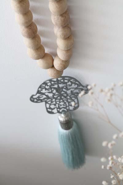 Decorative Hamsa wall hanging with wood bead accents, featuring intricate patterns and a natural, rustic aesthetic, ideal for adding a touch of cultural charm and spiritual significance to your home decor