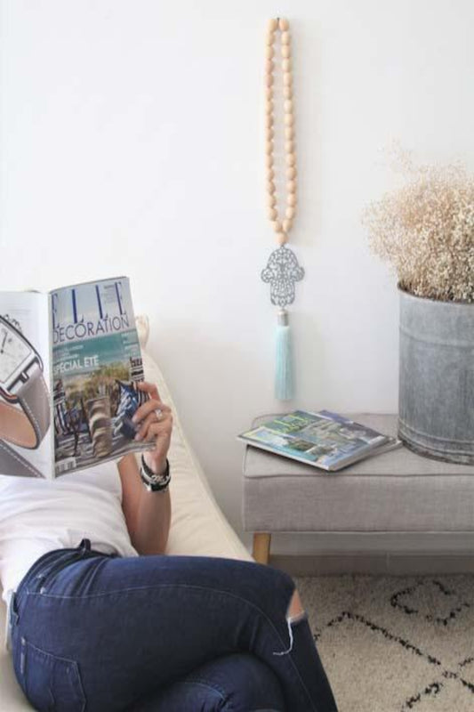 Decorative Hamsa wall hanging with wood bead accents, featuring intricate patterns and a natural, rustic aesthetic, ideal for adding a touch of cultural charm and spiritual significance to your home decor